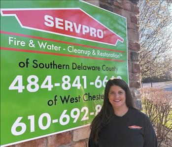 SERVPRO employee in front of franchise poster