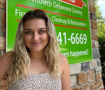young woman in front of a SERVPRO building