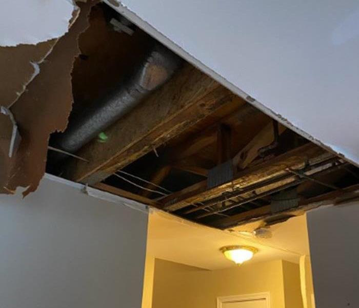 water damaged ceiling with ceiling ripped out exposing 2X4's 