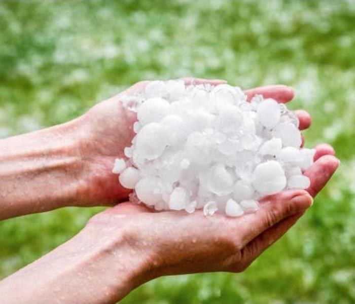 A person's hands filled with hailstones.